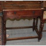 An early 18th century oak side table with a single drawer, wavy shaped apron and baluster legs, 75cm