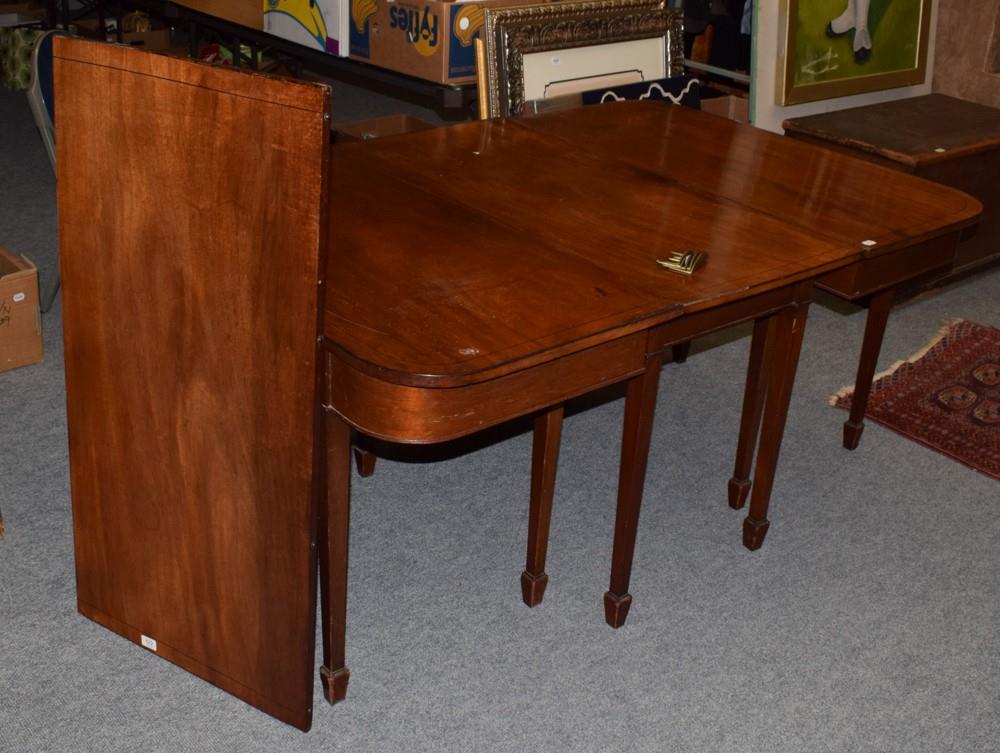 A George III string inlaid mahogany D-end dining table, raised on tapering square section legs and