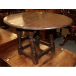 An early 19th century provincial oak drop-leaf table, raised on turned legs with block feet, 92cm (