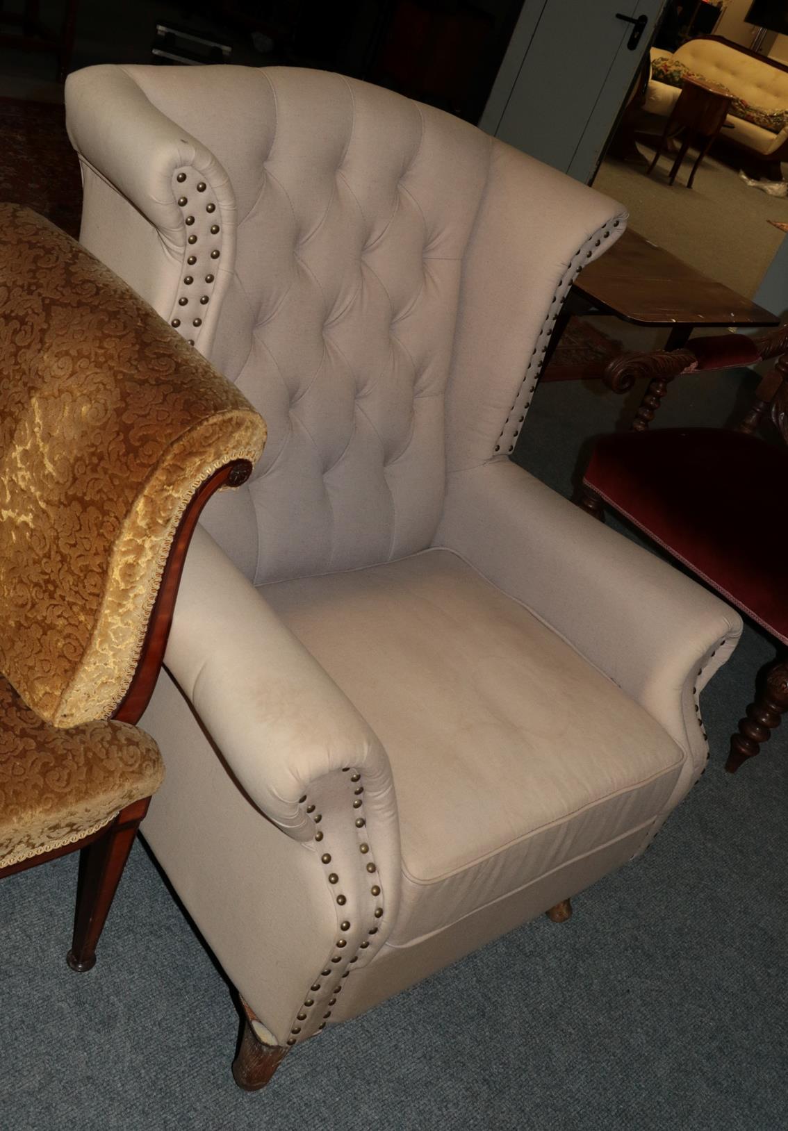 A George III style button-back wingback armchair with studded decoration