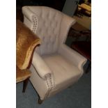 A George III style button-back wingback armchair with studded decoration