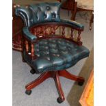 A reproduction blue buttoned leather swivelling office chair