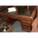 An early 20th century leather inset mahogany pedestal desk