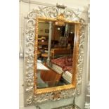 ^ A reproduction silver and gilt hall mirror with ornate scrolling leaf decoration