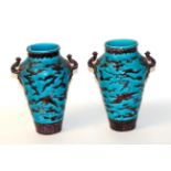 A pair of twin handled Continental vases decorated with Chinoiserie designs (a.f.