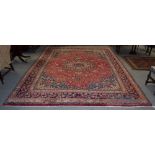 A large Herati rug, the central floral medallion on a red ground,