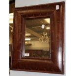 A reproduction mahogany cushion framed mirror, the rectangular mirror plate within a conforming