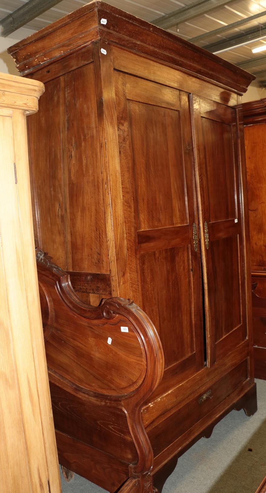 An 18th century French armoire with cupboard doors enclosing hanging space and a deep drawer to