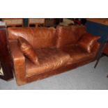 A brown leather four seater sofa