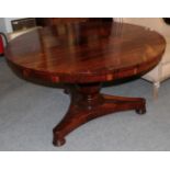 An early Victorian rosewood circular dining table raised on a faceted baluster support and a waisted