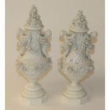 A pair of Meissen style porcelain urns and covers decorated with putti and flowers