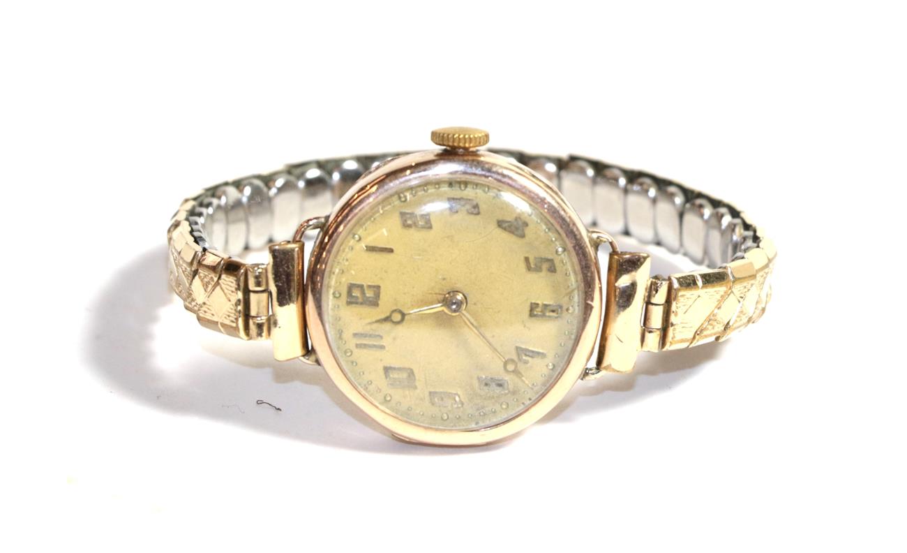 A gold wristwatch (Rolex movement)