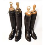 Two pairs of riding boots with boot trees