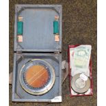 A cased RAF compass together with a small group of coins, banknotes and a lantern