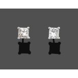 A Pair of Diamond Solitaire Earrings, the princess cut diamonds in white four claw settings, total