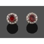 A Pair of Garnet and Diamond Cluster Earrings, the round cut garnet within a border of eight-cut