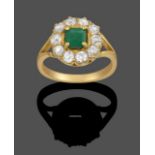 An 18 Carat Gold Emerald and Diamond Cluster Ring, the emerald-cut emerald within a border of old