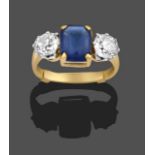 A Blue Glass and Diamond Three Stone Ring, the emerald-cut blue glass in yellow claw settings,