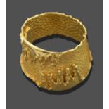 A Planished Hinged Bangle, the front applied with a yellow plain polished melted wax motif, inner