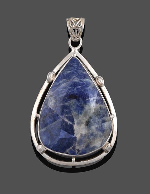 An Iolite Pendant, the pear cut iolite in a white rubbed over setting to a fancy border, measures