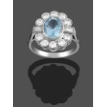 An Aquamarine and Diamond Cluster Ring, the oval cut aquamarine within a border of round brilliant