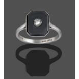 A Diamond and Onyx Ring, the emerald-cut onyx plaque with a round brilliant cut diamond set