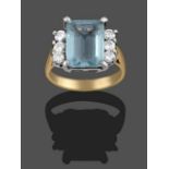 An Aquamarine and Diamond Ring, the emerald-cut aquamarine sits between trios of round brilliant cut