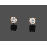 A Pair of Diamond Solitaire Earrings, the round brilliant cut diamonds in yellow four claw settings,