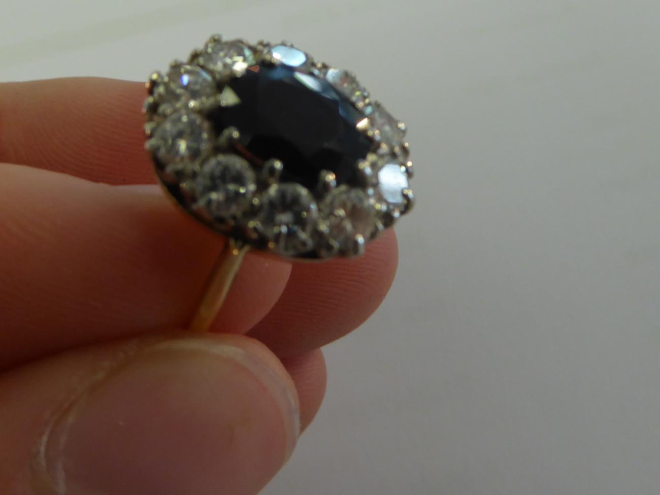 A Sapphire and Diamond Cluster Ring, the oval cut sapphire within a border of round brilliant cut - Image 4 of 5