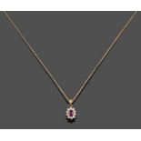 A Ruby and Diamond Cluster Pendant on Chain, the oval cut ruby within a border of round brilliant
