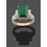 A 9 Carat Gold Emerald and Diamond Ring, the emerald-cut emerald in a yellow four claw setting, to