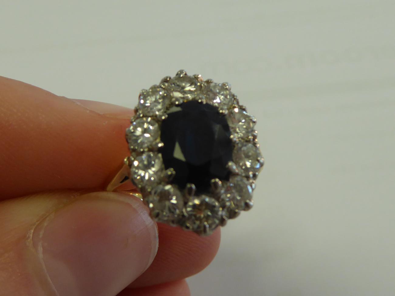 A Sapphire and Diamond Cluster Ring, the oval cut sapphire within a border of round brilliant cut - Image 5 of 5