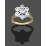 A Diamond Cluster Ring, seven round brilliant cut diamonds in yellow claw settings, to a textured