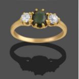 A Green Glass and Diamond Three Stone Ring, the oval cut green glass flanked by two old cut