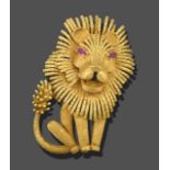 A Lion Brooch, realistically modelled as a seated lion, with ruby set eyes in yellow claw settings
