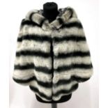 A Chinchilla Rex Fur Grey Capelet Style Hooded Jacket, striped in dove and charcoal grey, with