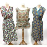 Assorted Circa 1950s/1960s Aprons and House Coats, in decorative printed cottons on tabards, house