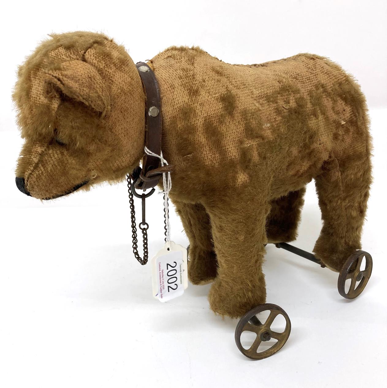 An Early 20th Century Steiff Pull Along Bear on Wheels, with jointed head, boot button eyes,