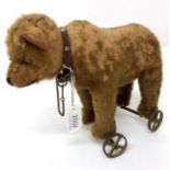 An Early 20th Century Steiff Pull Along Bear on Wheels, with jointed head, boot button eyes,