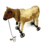 Late 19th Century Pull Along Cow, possibly German, with hide covered body, real horns, glass eyes,
