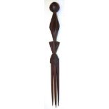 A Fijian Cannibal Fork, of dark reddish wood, with four long tangs, triangular block carved grip and