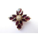 A Victorian Garnet and Diamond Brooch, measures 3.3cm by 3.1cm. Gross weight 4.6 grams.