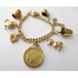 A Charm Bracelet, stamped '9' and '.375', hung with various charms including a 1903 sovereign, a