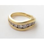 An 18 Carat Gold Diamond Ring, graduated round brilliant cut diamonds channel set in an undulating