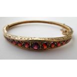 A Victorian Garnet Bangle, stamped '9CT' . Gross weight 17.6 grams.