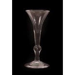 A Wine Glass of Kit-Kat Type, circa 1720, the drawn trumpet bowl on knopped stem and folded foot,