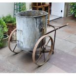An Anodised and Wrought Iron Water Carrier/Trolley, the oval container mounted on yoke supports,