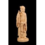 A Japanese Ivory Okimono of a Sage, Meiji period, standing in flowing robes holding a peach and