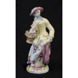 A Bow Porcelain Figure of a Lady, circa 1760, standing wearing a yellow jacket and flowered skirt, a
