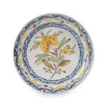 An English Delft Plate, mid 18th century, painted in colours with a central flowerspray within